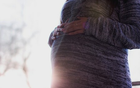 woman in jumper with a pregnant belly
