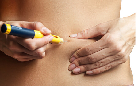 Woman injecting ivf hormones into her abdomen