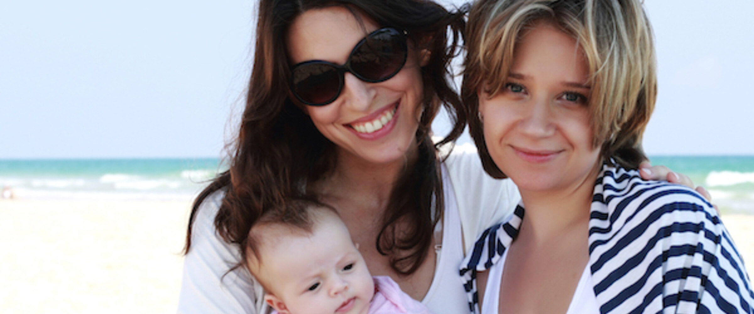 couple with baby on beach